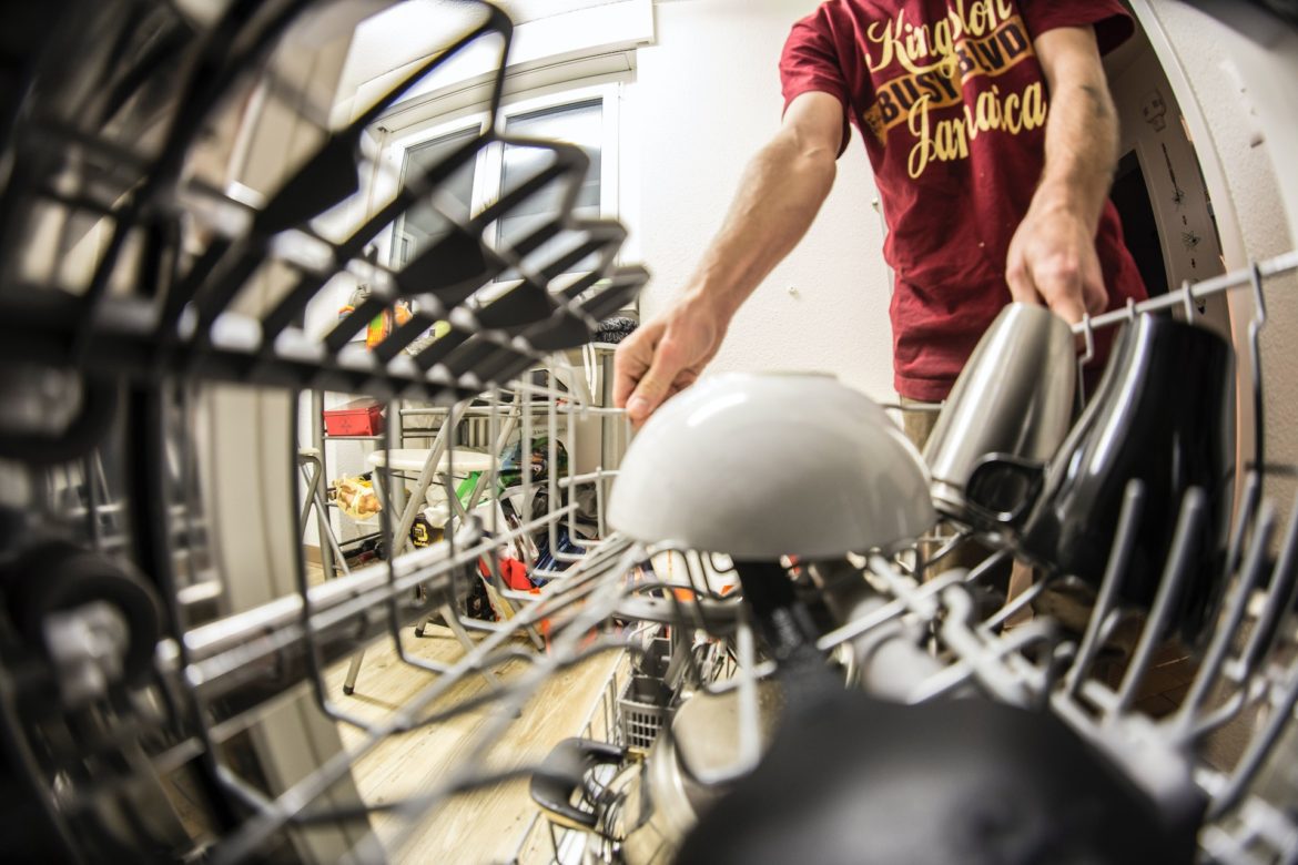 a man putting dishwasher pod inside a dishwasher