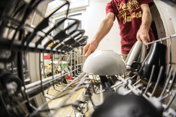 a person putting dishes in a dishwasher a man putting dishwasher pod inside a dishwasher