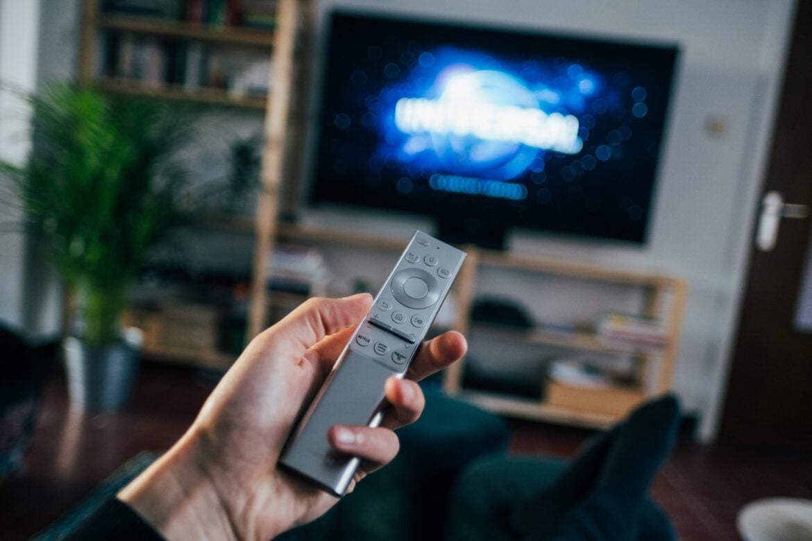 a man holding a 32-inch android tv remote control