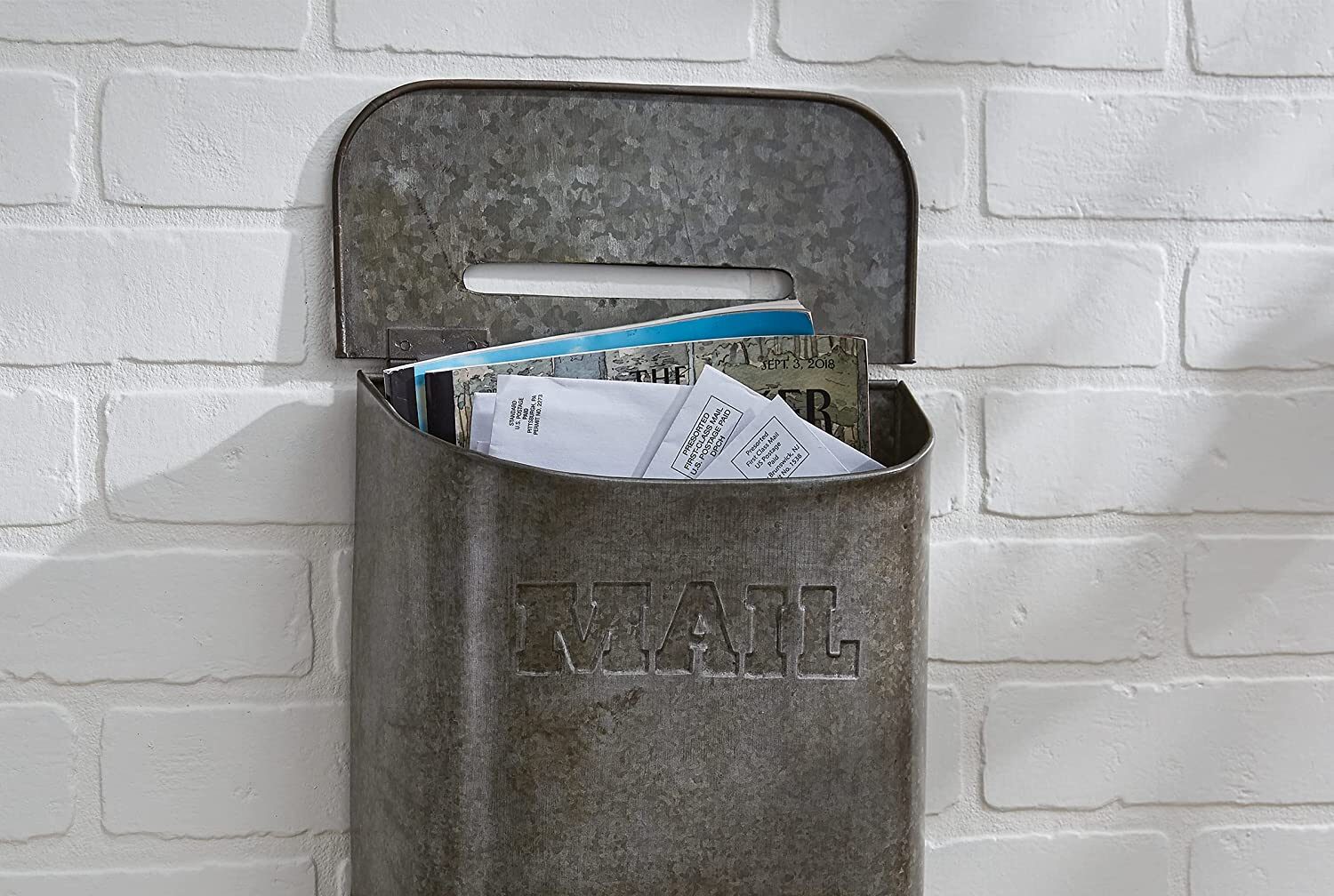 a galvanized metal mailbox hanging in a farmhouse entryway