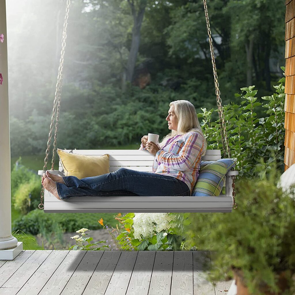 a woman sitting on a farmhouse porch swing