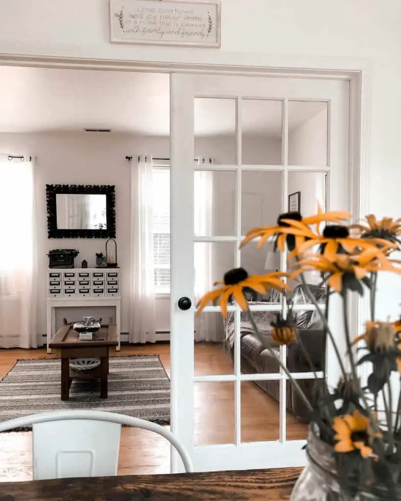 Fusion of Tradition and Modernity: White French Doors Frame the Farmhouse Vignette