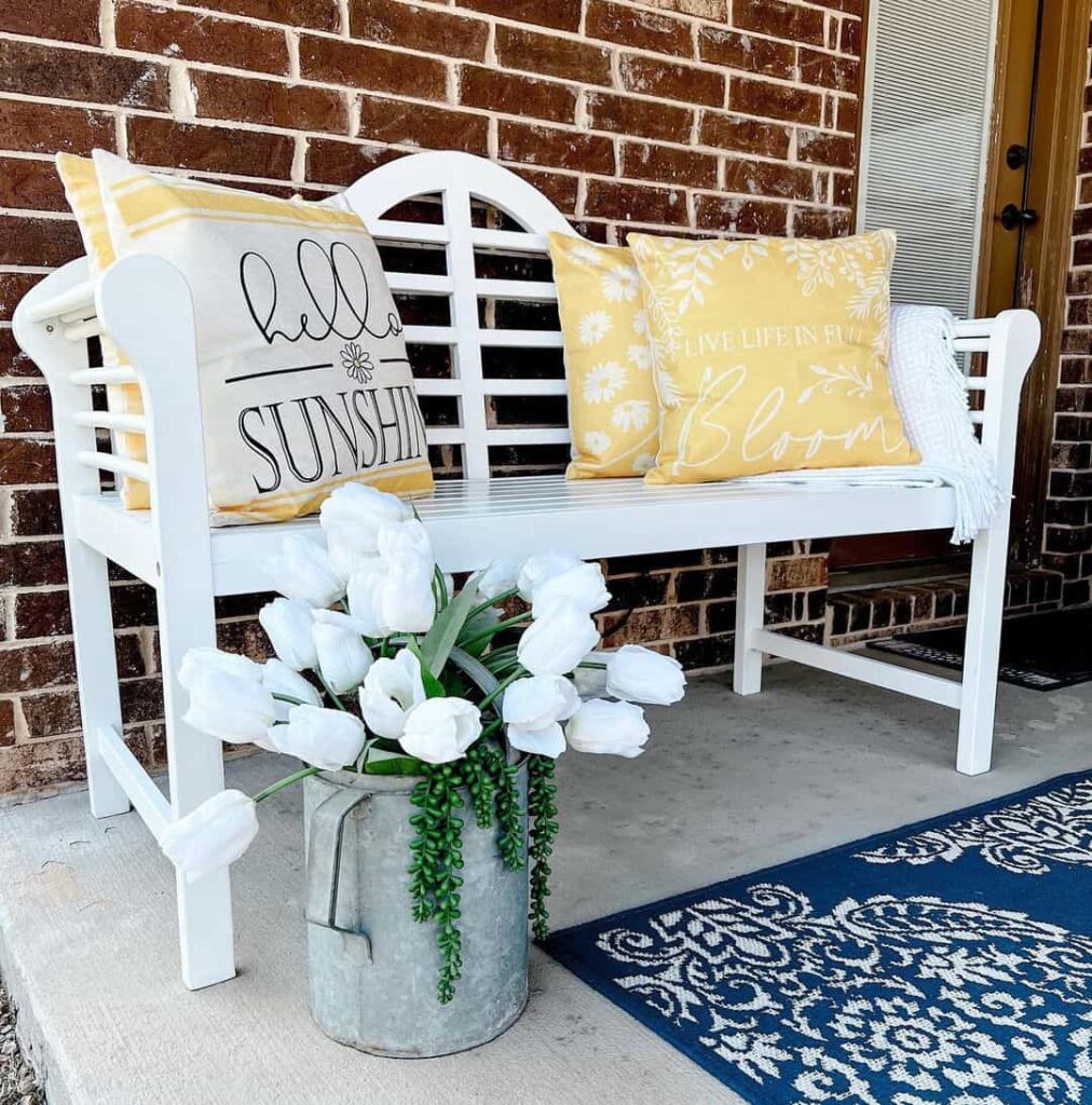 White Patio Bench Adorned With Yellow and White Pillows