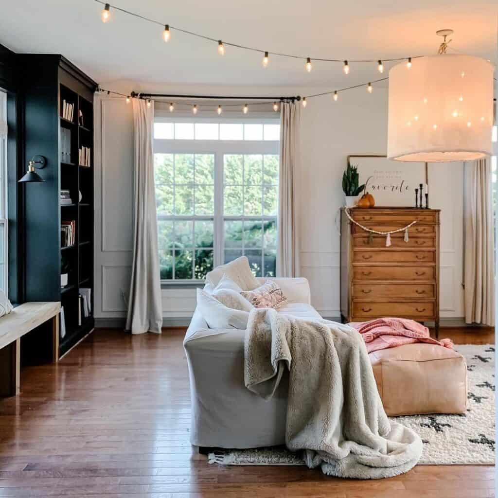 Contemporary Black Bookcase Illuminated by Farmhouse Sconce Lights