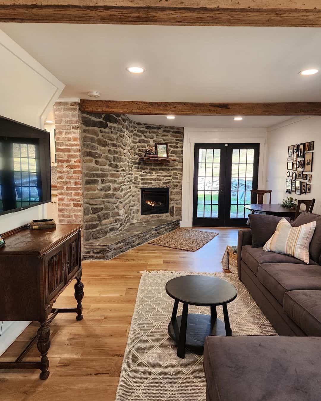 A Cozy Farmhouse Family Room Featuring an Exposed Stone Fireplace