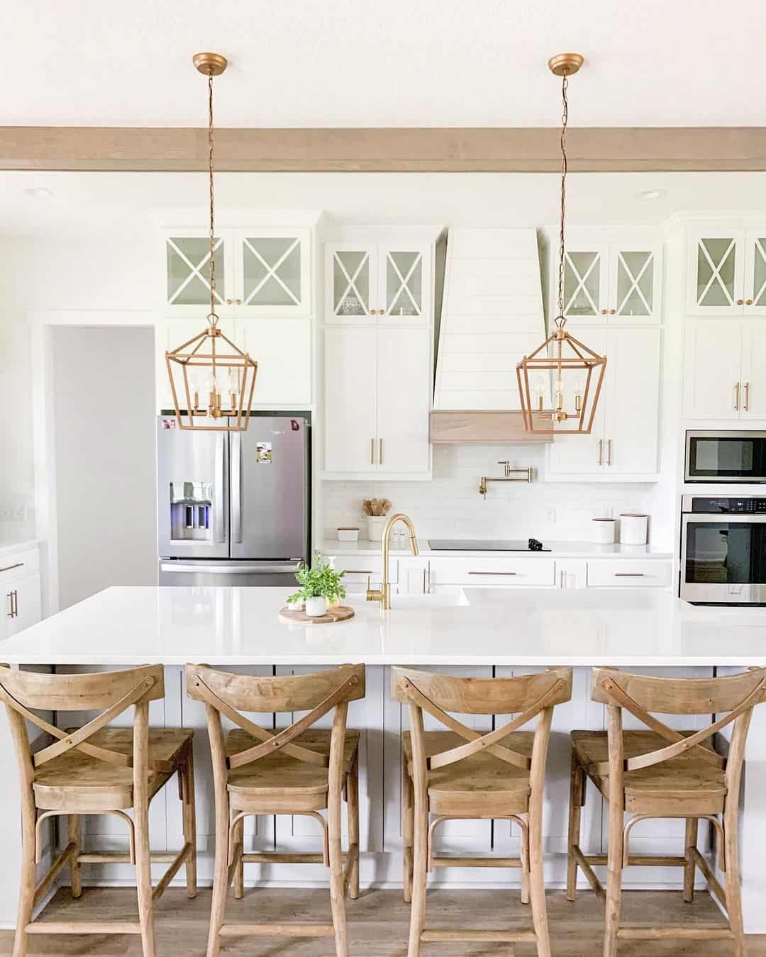 Bright White Kitchen Enhanced by Brass Light Fixtures and Marble Countertops