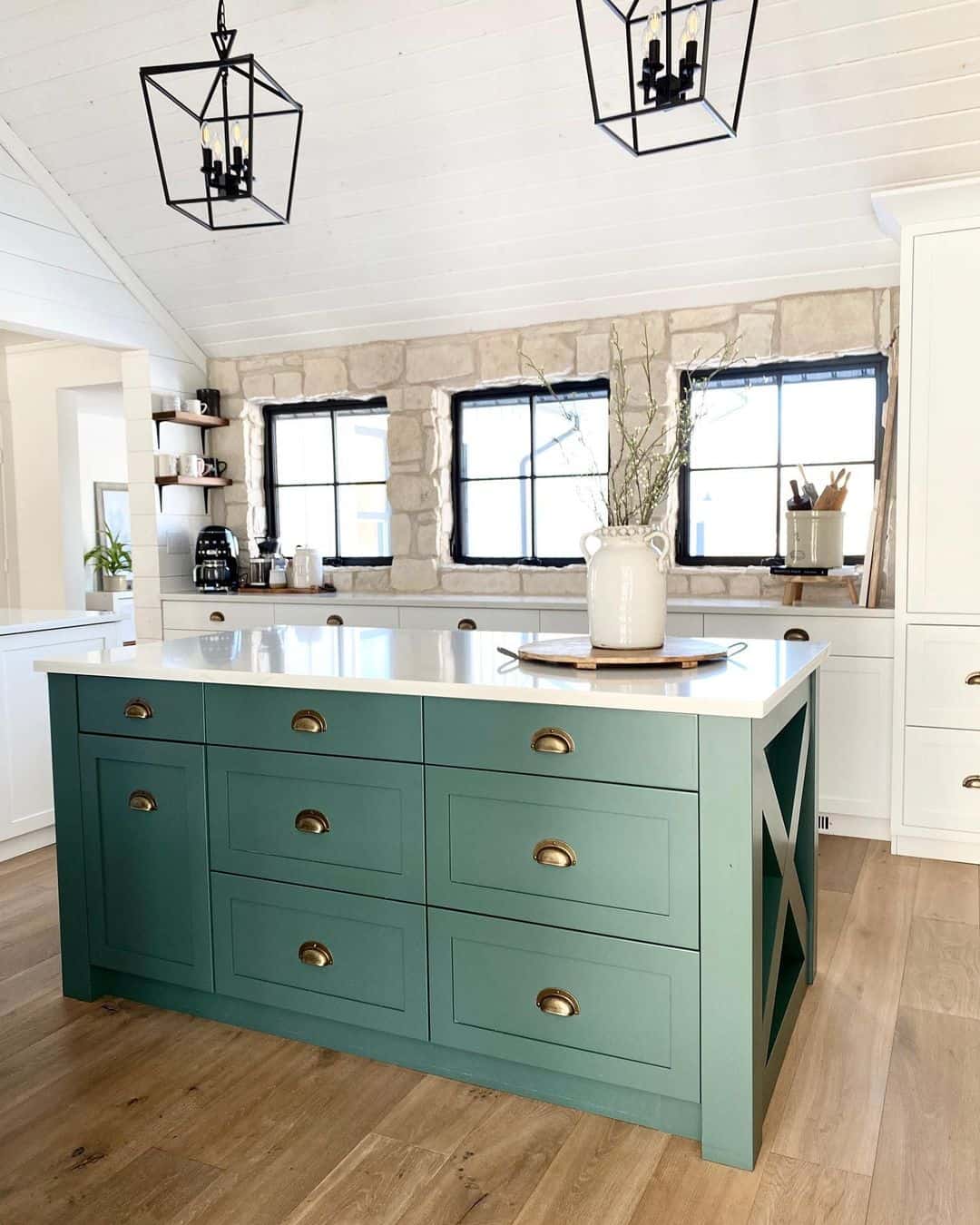 Sage Green Cabinets Illuminated by Black Pendant Lamps