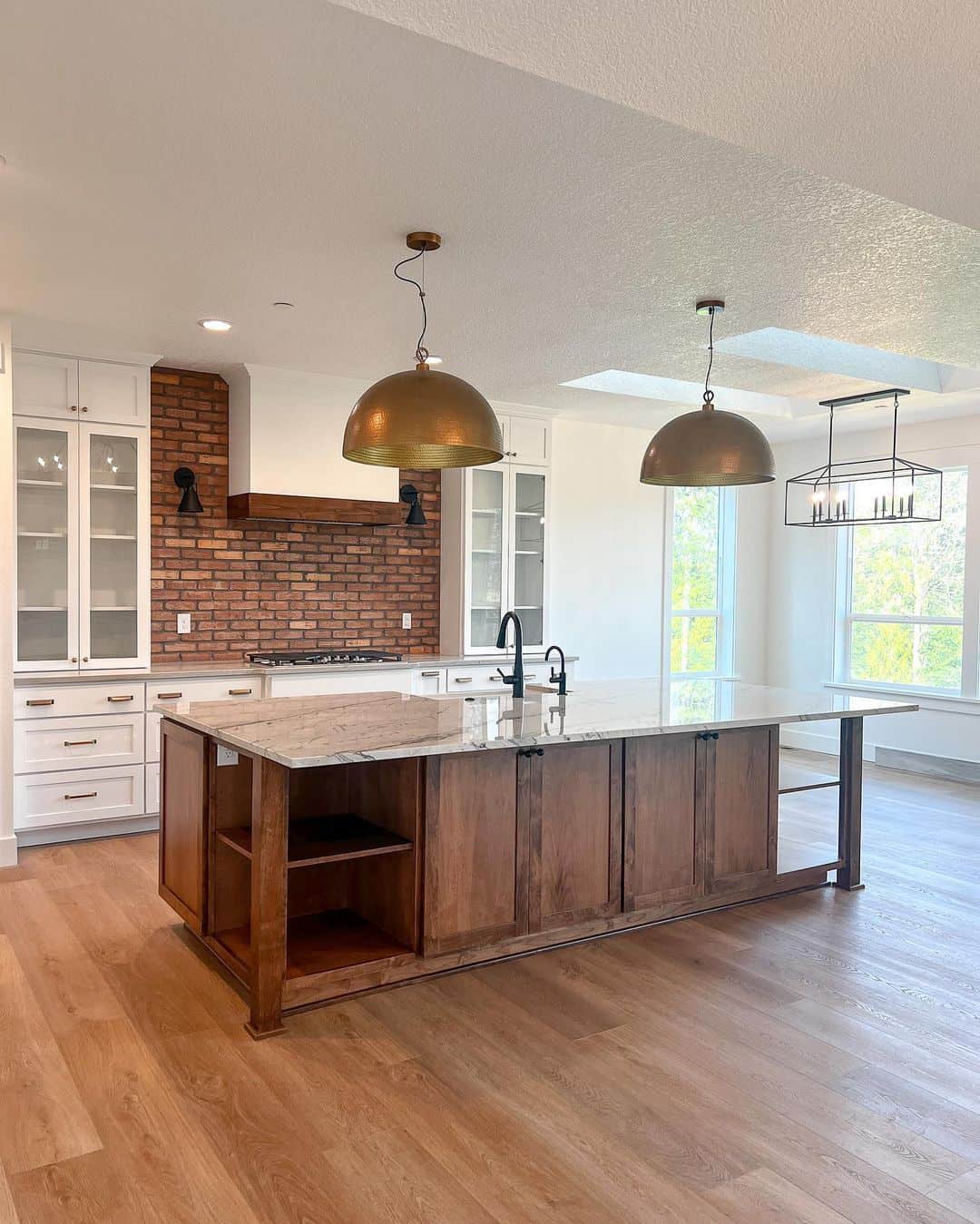 Illuminating the Kitchen with Black Sconces and a Brick Backsplash