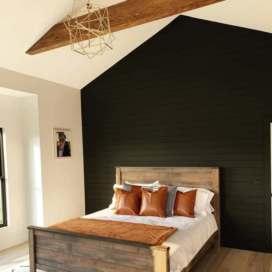 Bedroom adorned with a Black Shiplap Wall and Exposed Wood Beams