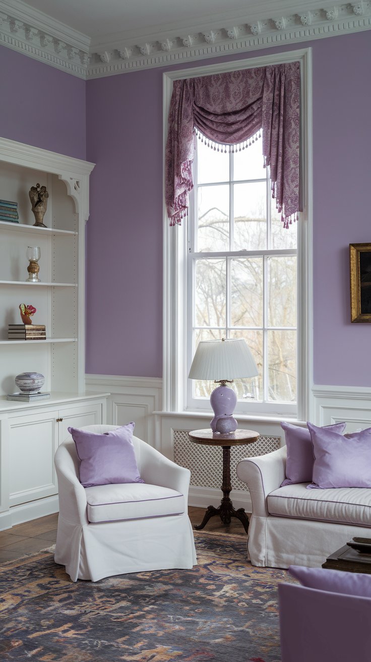 A photo of a Victorian living room with lavender walls and white wainscoting. There's a large window with a patterned curtain. A white sofa with lavender pillows sits near the window. A white chair with lavender cushions is placed near the sofa. A round table with a lavender lamp is placed between the sofa and chair. A white bookshelf with decorative items is placed on the left wall. The room has a patterned rug.