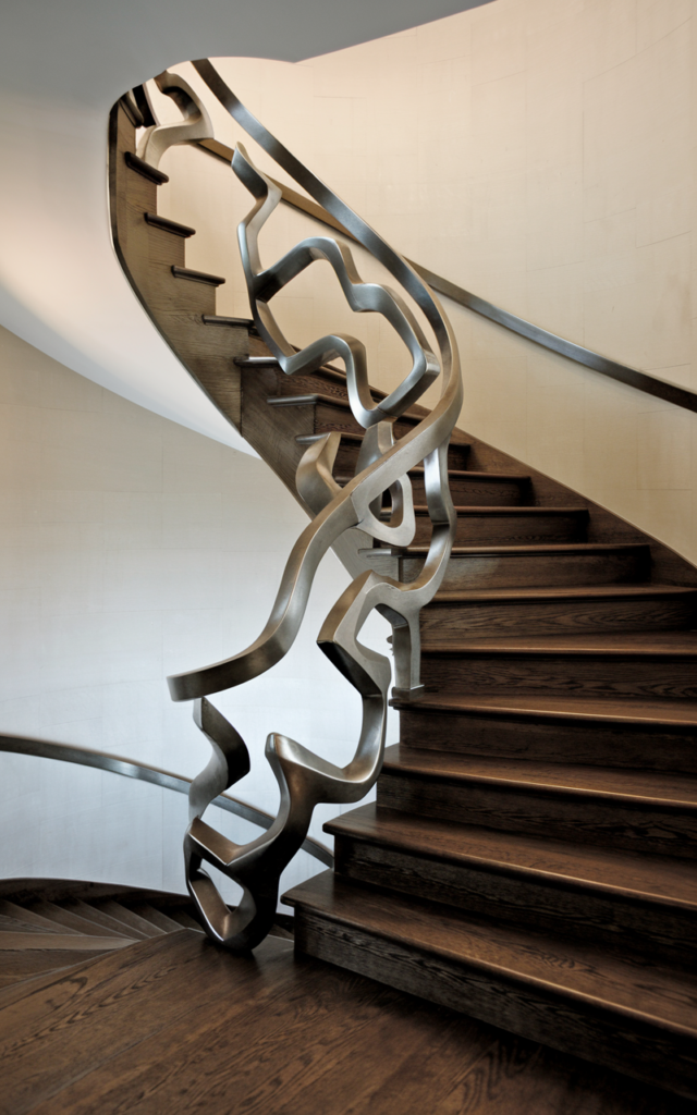 An elegant and natural-looking realistic photograph of a staircase with a bold sculptural custom handrail shaped like flowing geometric waves beside dramatic modern stairs acting as a central art feature decorated in modern luxury architectural home decor style with natural lighting