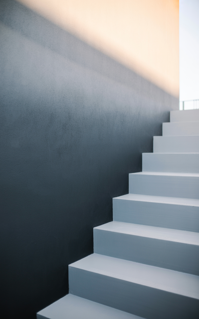 Paint an ombré fade from black to white along the wall
